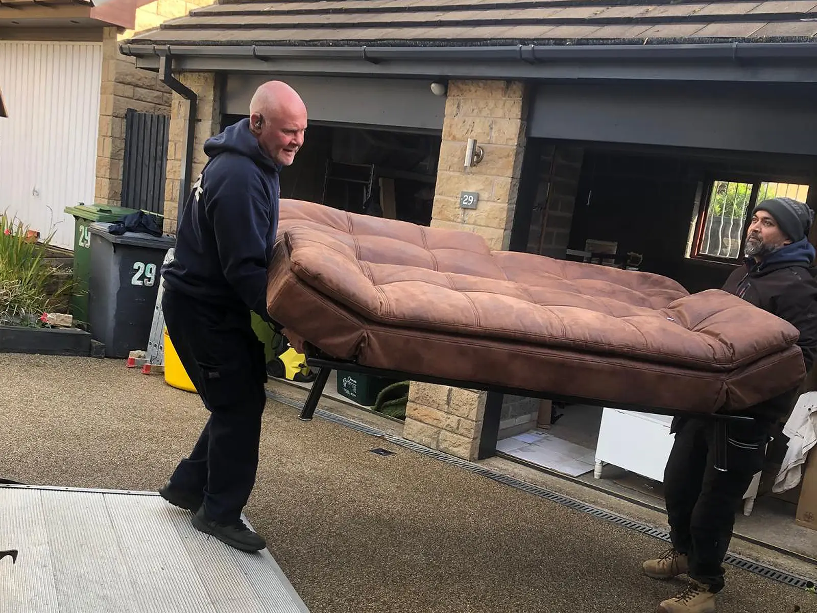 On The Move Removals team carrying a sofa onto the van during a Huddersfield house move
