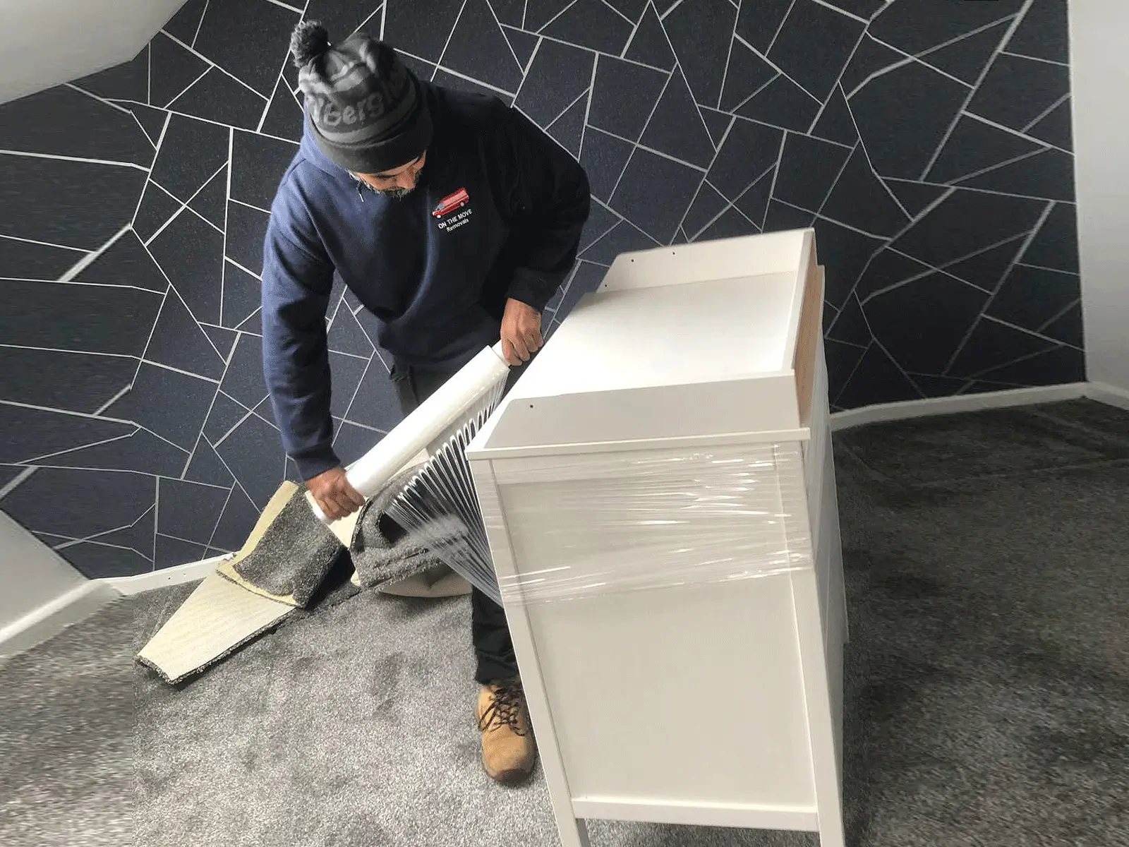 On The Move Removals team member wrapping furniture for safe transport during a Huddersfield move